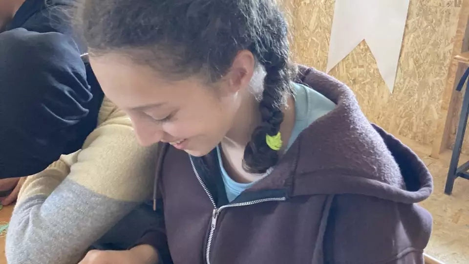 A student does crafts in our tent village in Turkey after the earthquake in 2023