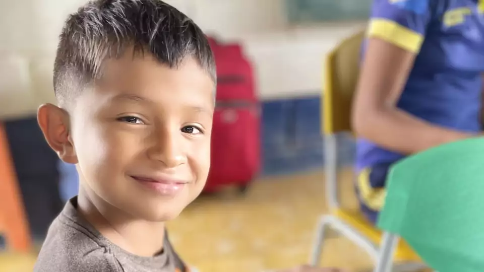 A student in Colombia beams with pride over his work