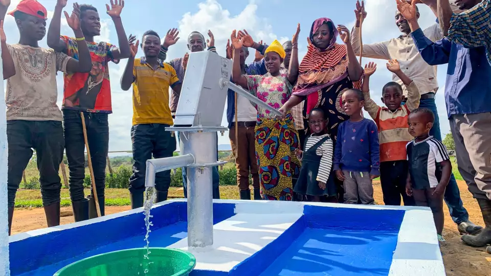 Families celebrate as clean water flows from the hand pump, and with your contribution, we can bring hope to the 1 in 11 people who lack access to safe water.