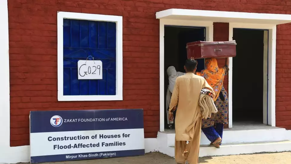 A family in Mirpu Khas, Pakistan moves into their new home after losing theirs to the floods.