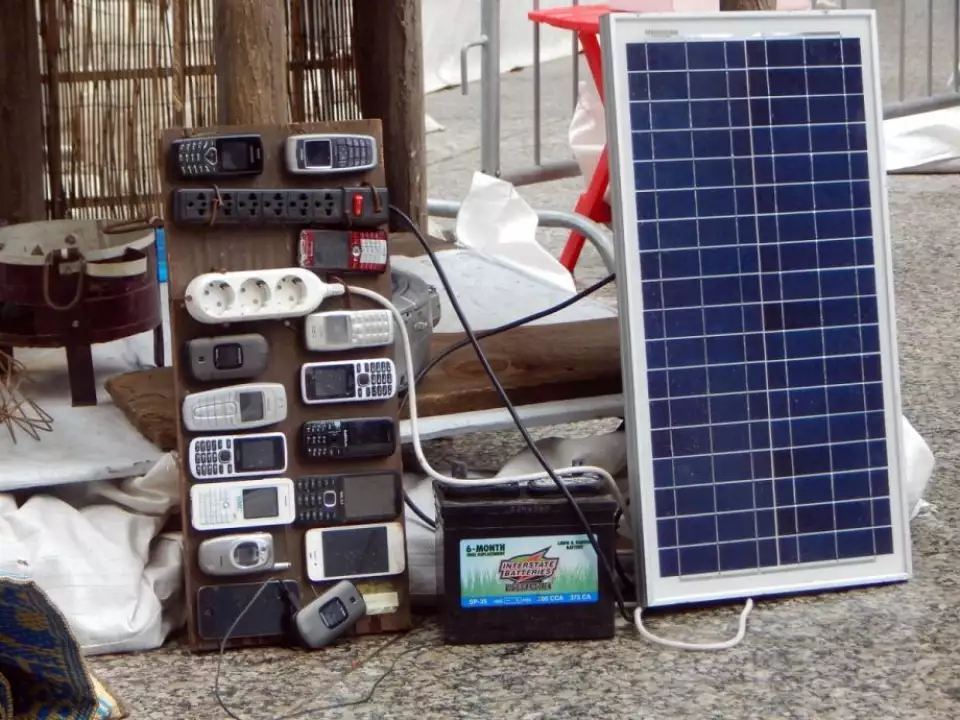 Cell phones and a makeshift charging apparatus that can be found in refugee camps around the world. (Photo by Audrey Henderson)