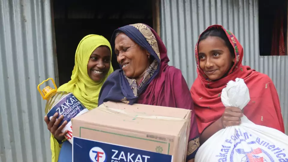 A Bangladeshi family is all smiles when receiving their Ramadan package