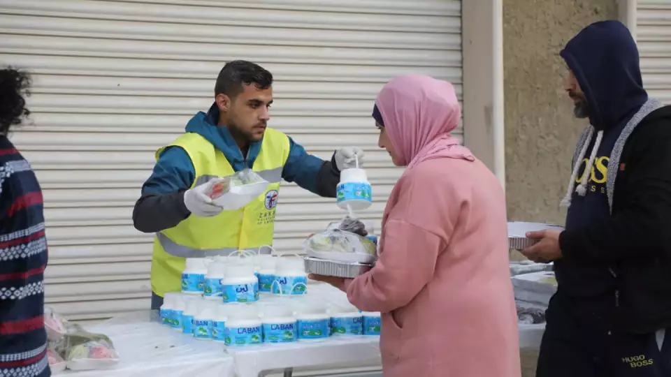 Zakat Foundation of America workers hand food to those in need