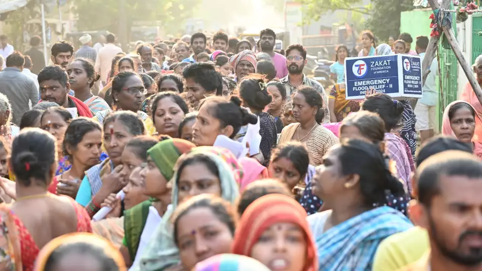 Countless families in India line up to collect emergency flood relief supplies.