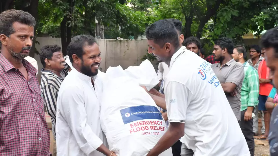 Families in India affected by the flood receive emergency relief items.