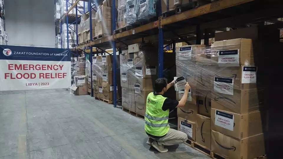 USA team member labels boxes of emergency relief supplies for families in Libya affected by the floods.